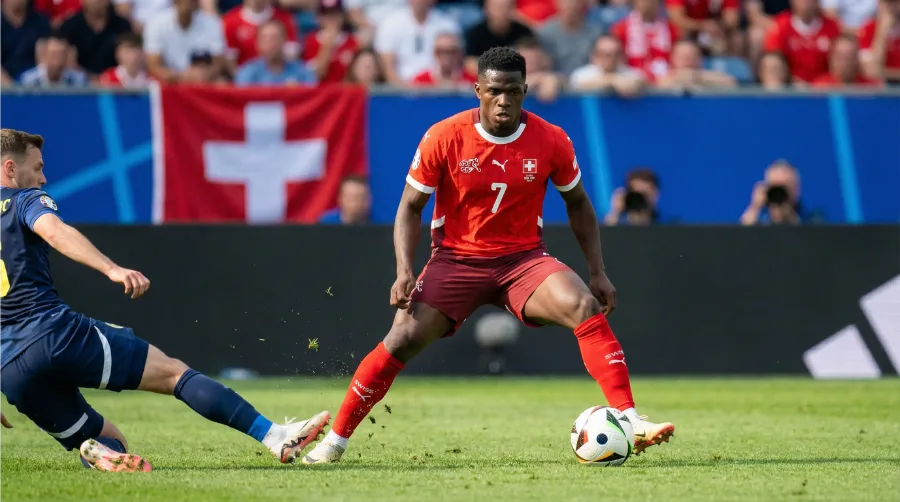 Schweizer Nationalspieler im roten Trikot bei einem entscheidenden Zweikampf während eines WM-Qualifikationsspiels