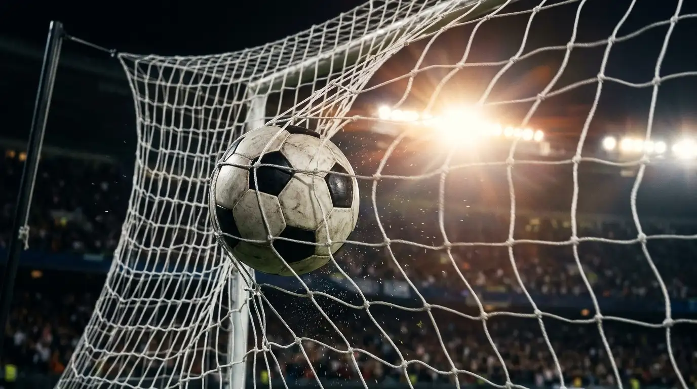 Fussball im Tornetz nach einem verwandelten Schuss, Flutlicht im Hintergrund
